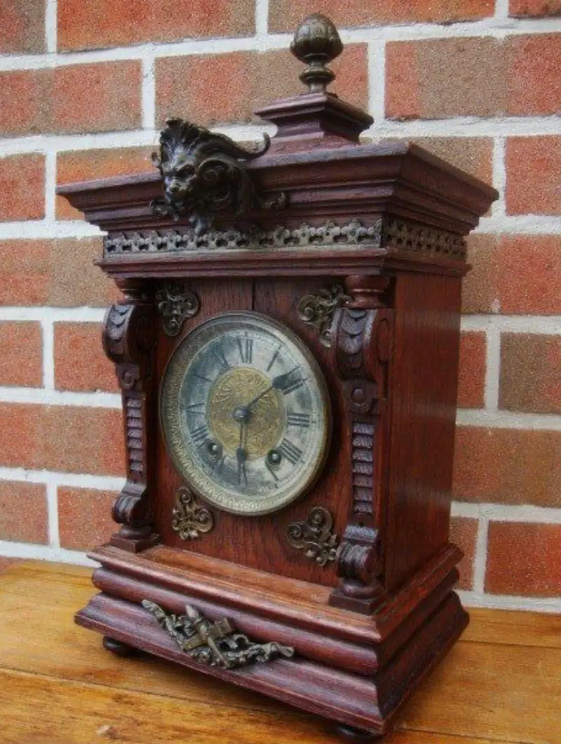 Antieke houten tafelklok met versierde wijzerplaat