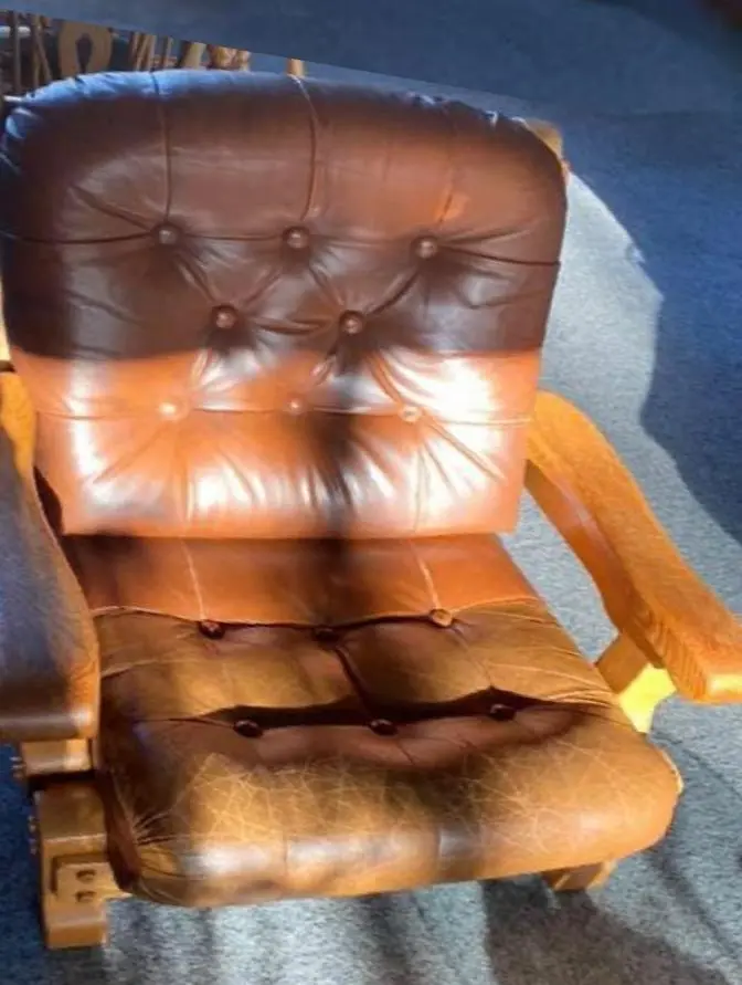 Leren fauteuil met knopen, half behandeld: boven nog verschoten, onder al hersteld