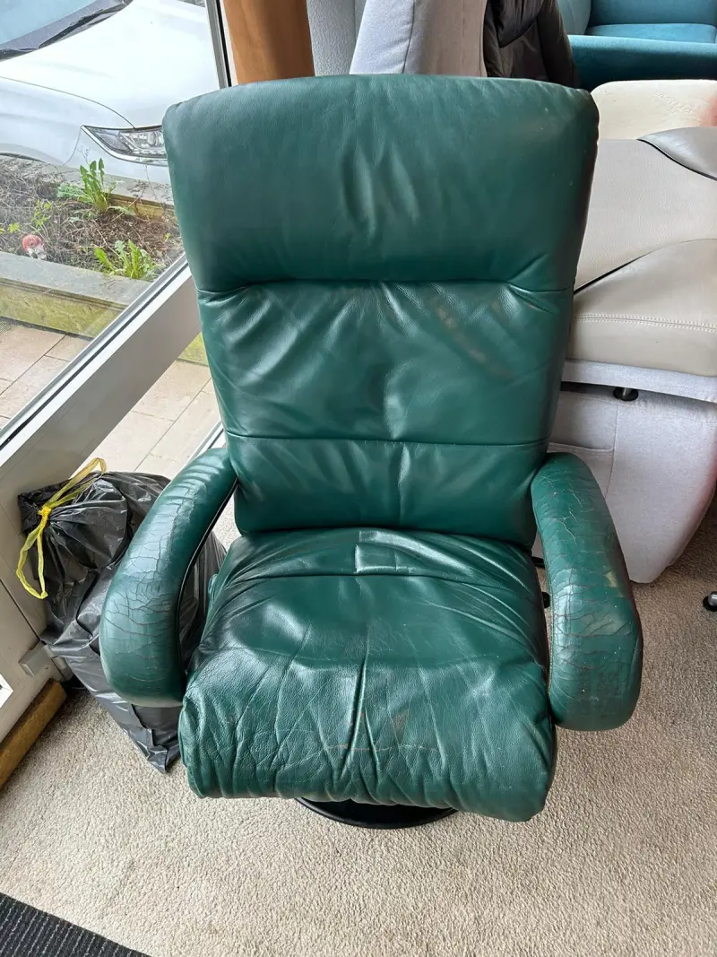 Groene leren relaxfauteuil met sleetse plekken