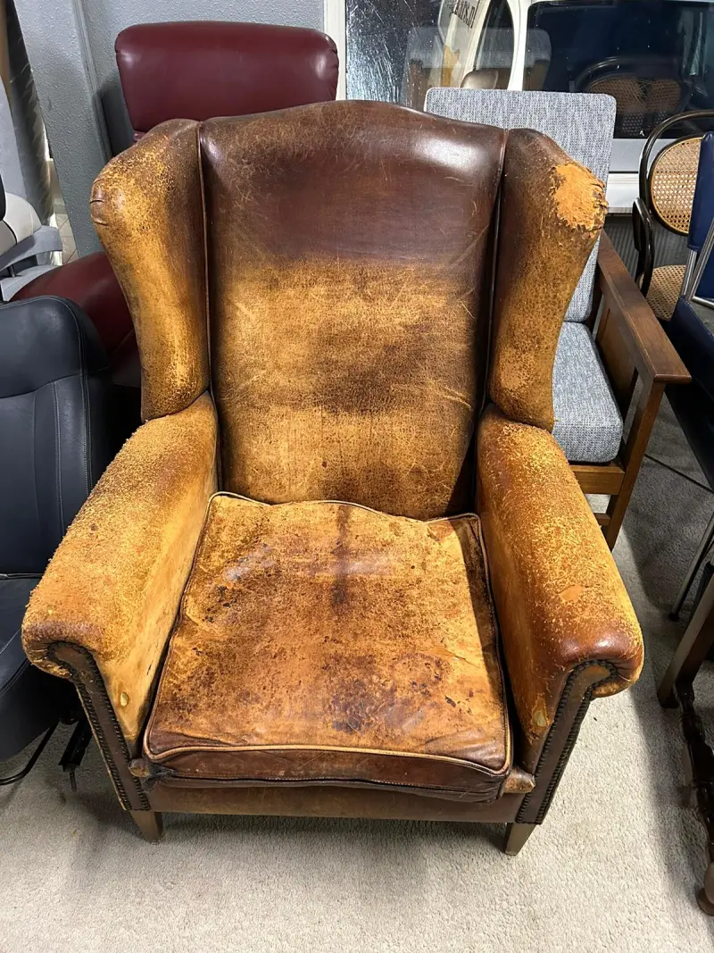 Versleten oorfauteuil voor het herstofferen