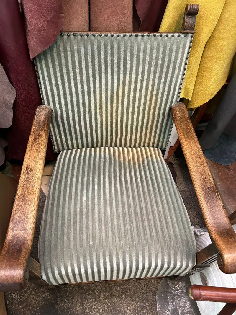 Armstoel met versleten gestreepte bekleding