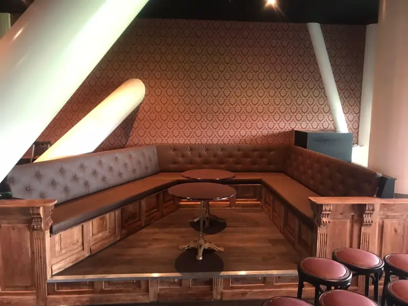 Gestoffeerde hoekbank met capitonné rug in een skybox