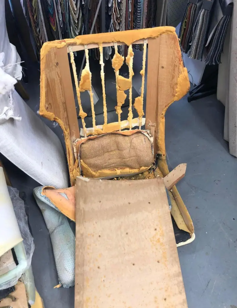 Kaal frame van een fauteuil in de werkplaats, klaar voor restauratie